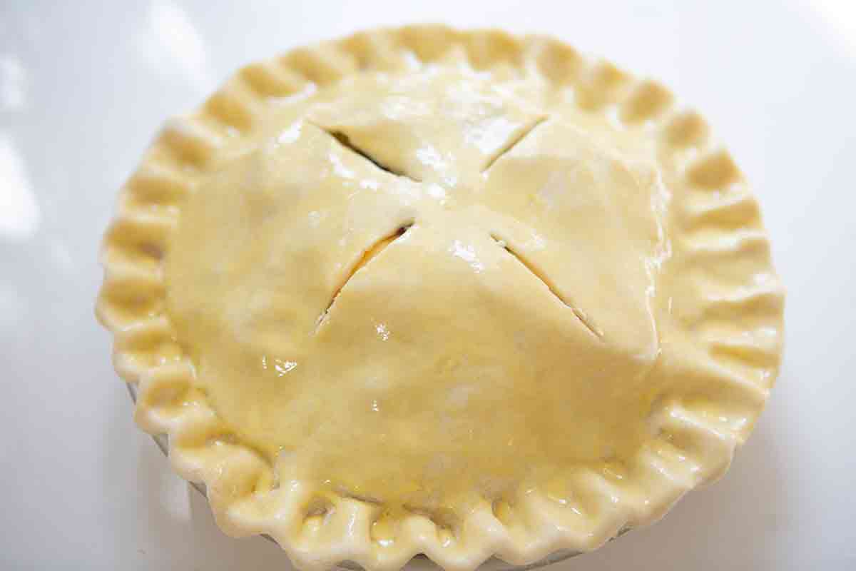 apple cranberry pie brushed with egg wash and about to go into the oven