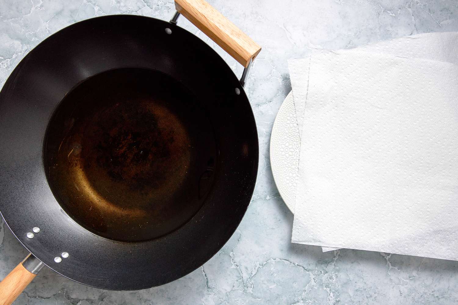 Wok Filled With Frying Oil Next to a Plate Lined With Paper Towels