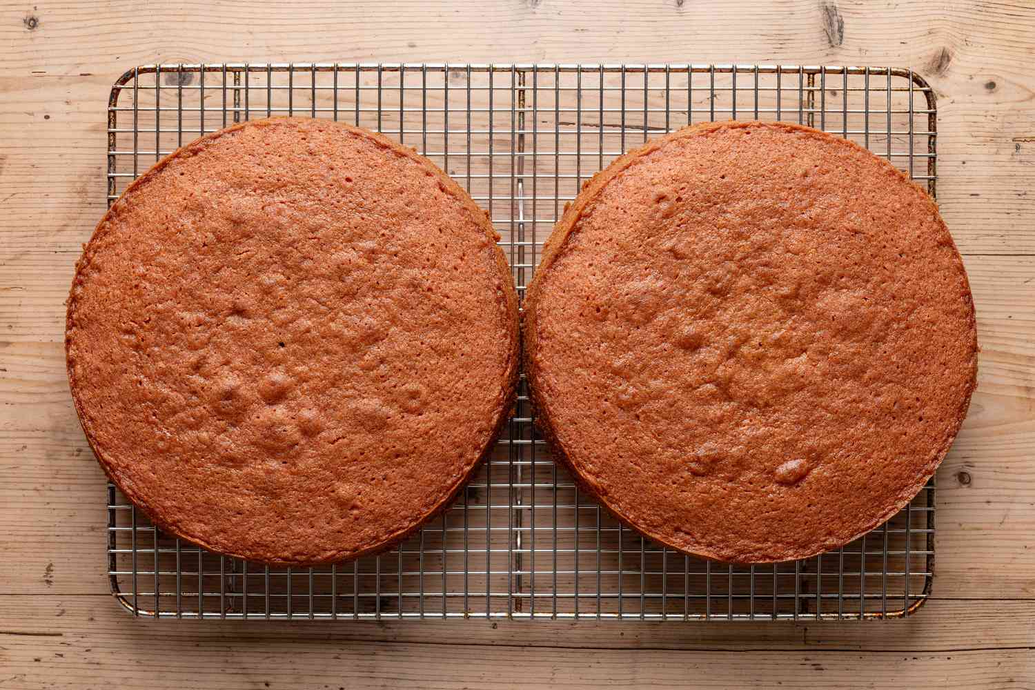 strawberry cake resting on cooling rack (not in the baking pans)