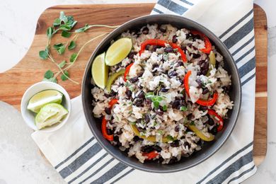 A bowl of black bean rice on a striped linen.