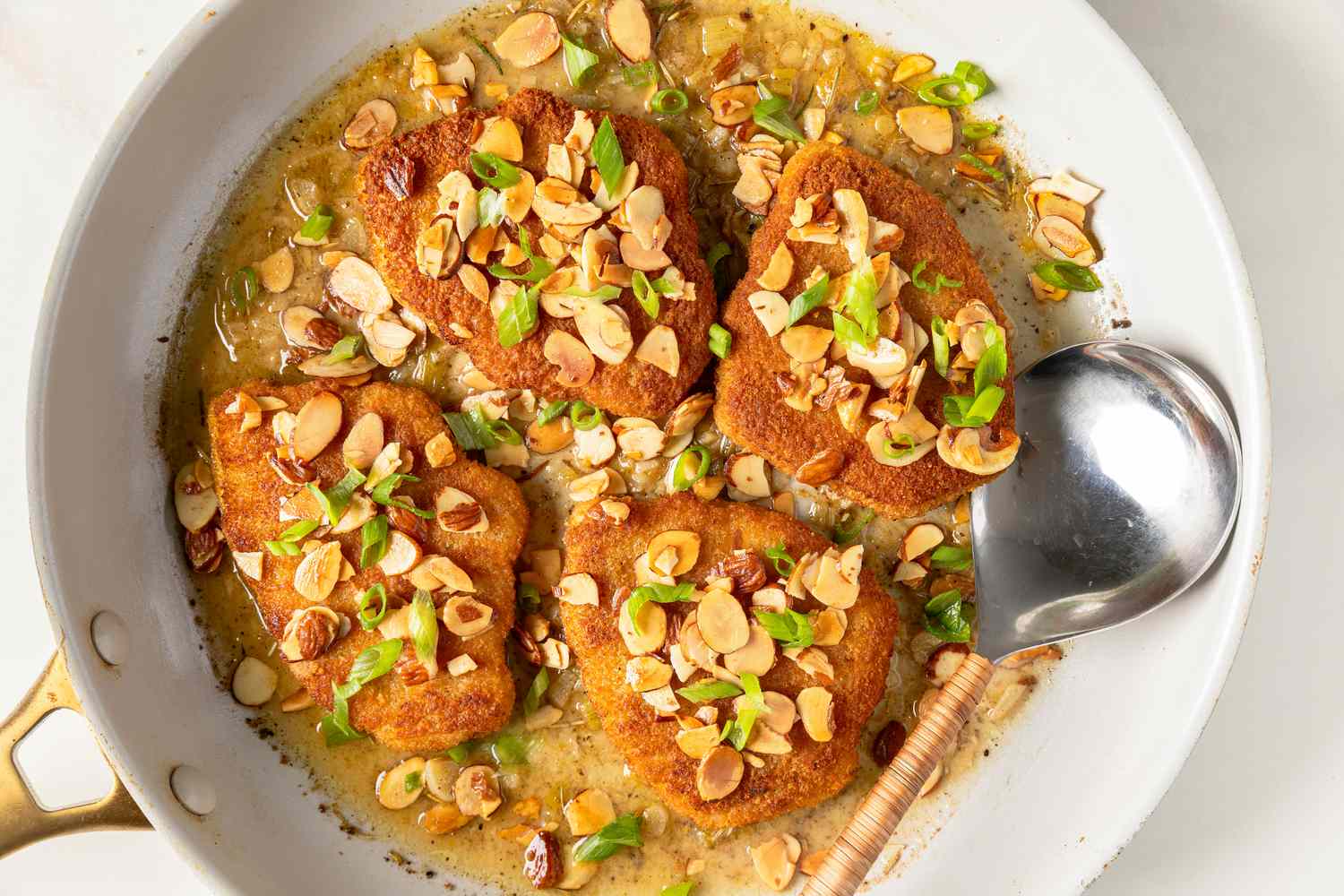 Easy Chicken Almondine in a skillet with a large serving spoon