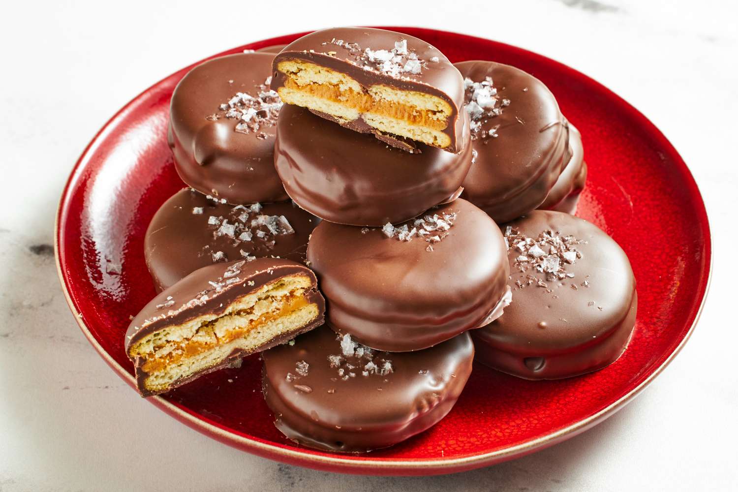 Stacked chocolatecovered Ritz crackers with peanut butter filling on a red plate