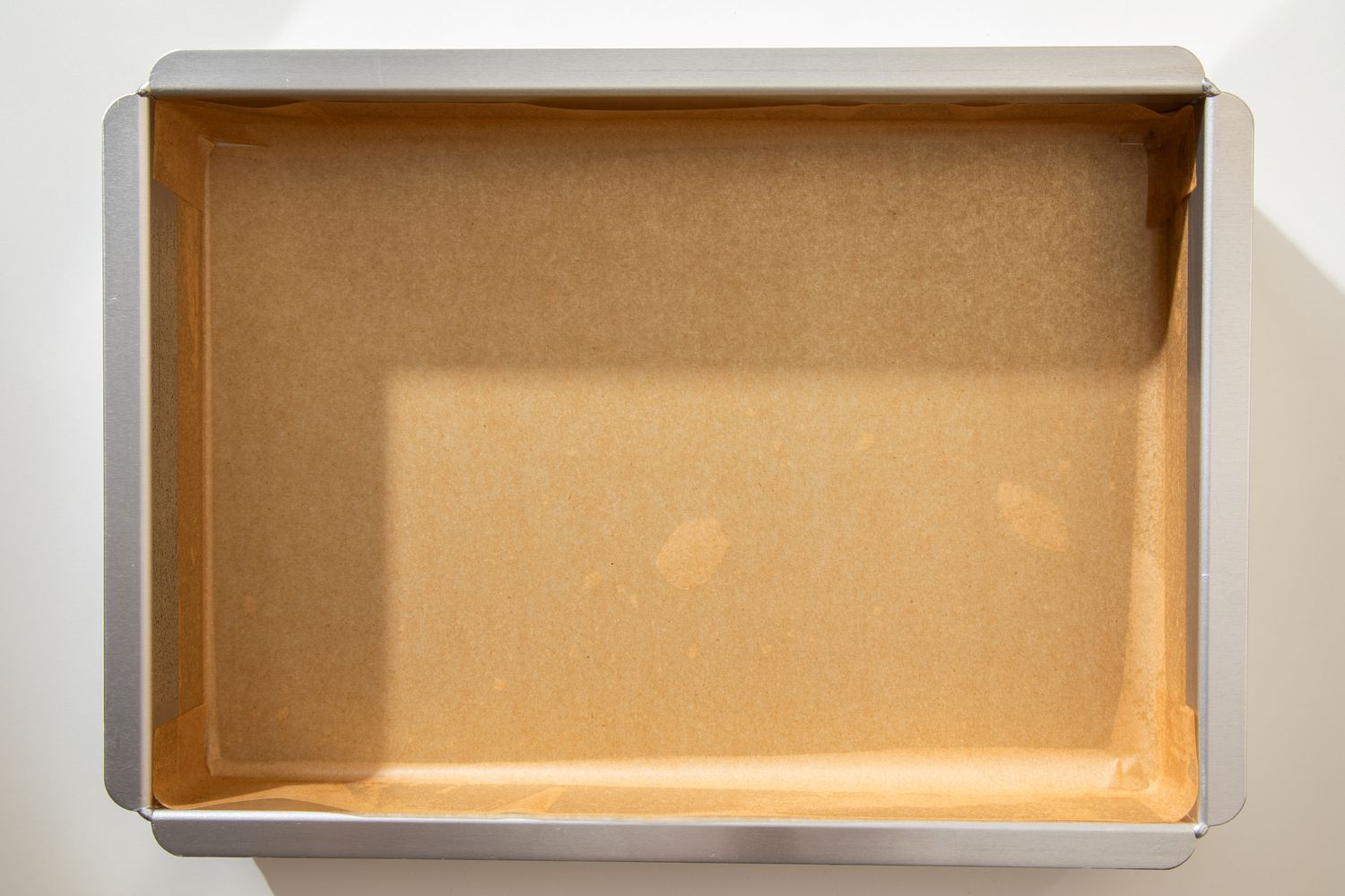 Parchment paper-lined baking pan for salted honey rolls recipe