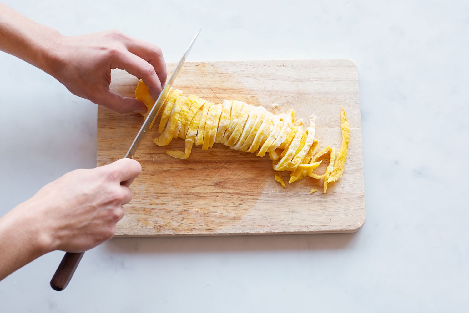 Slicing the rolled omelet for a rice cake soup.