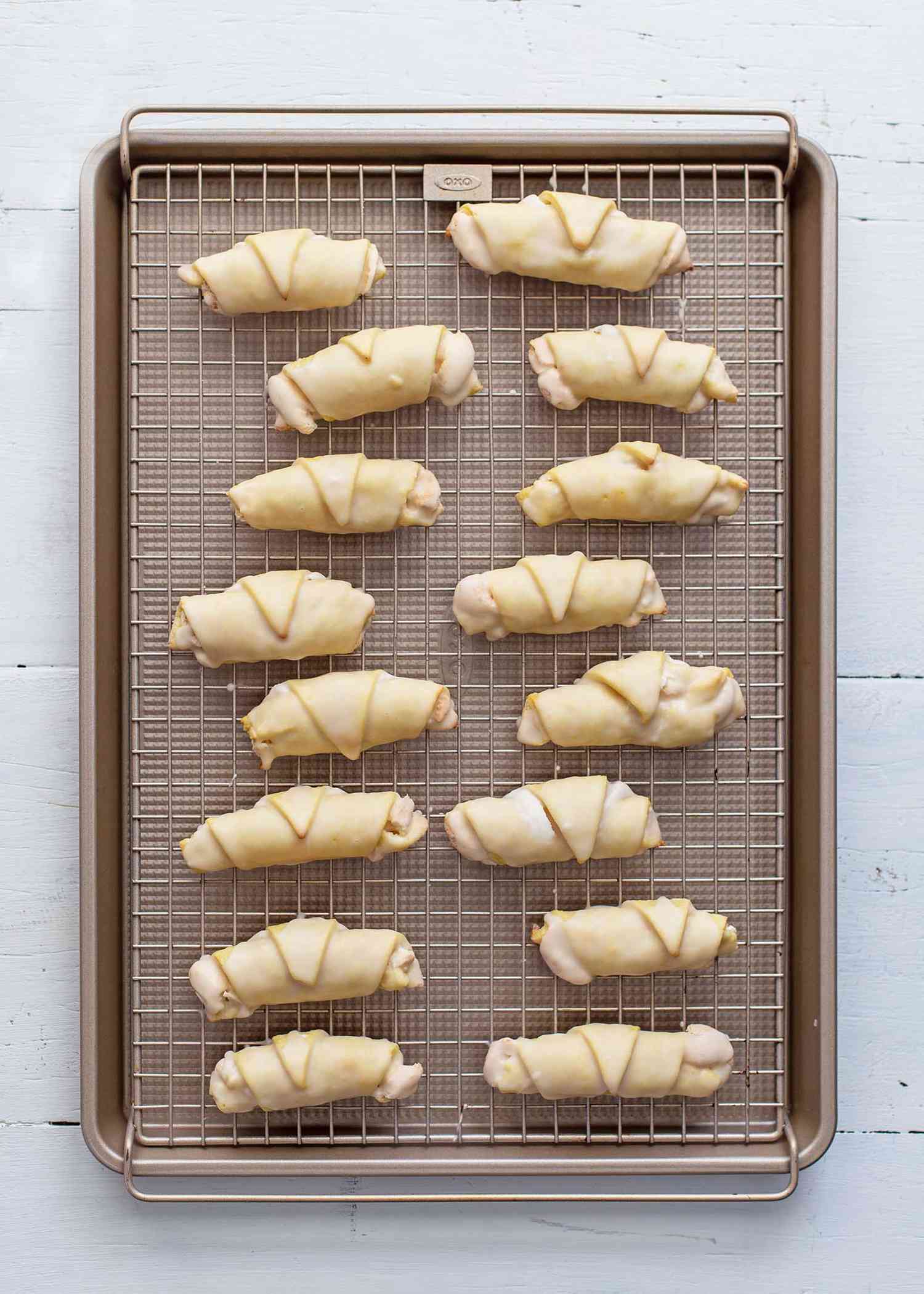 Hungarian Nut Horns set on a cooling rack inside a baking sheet.