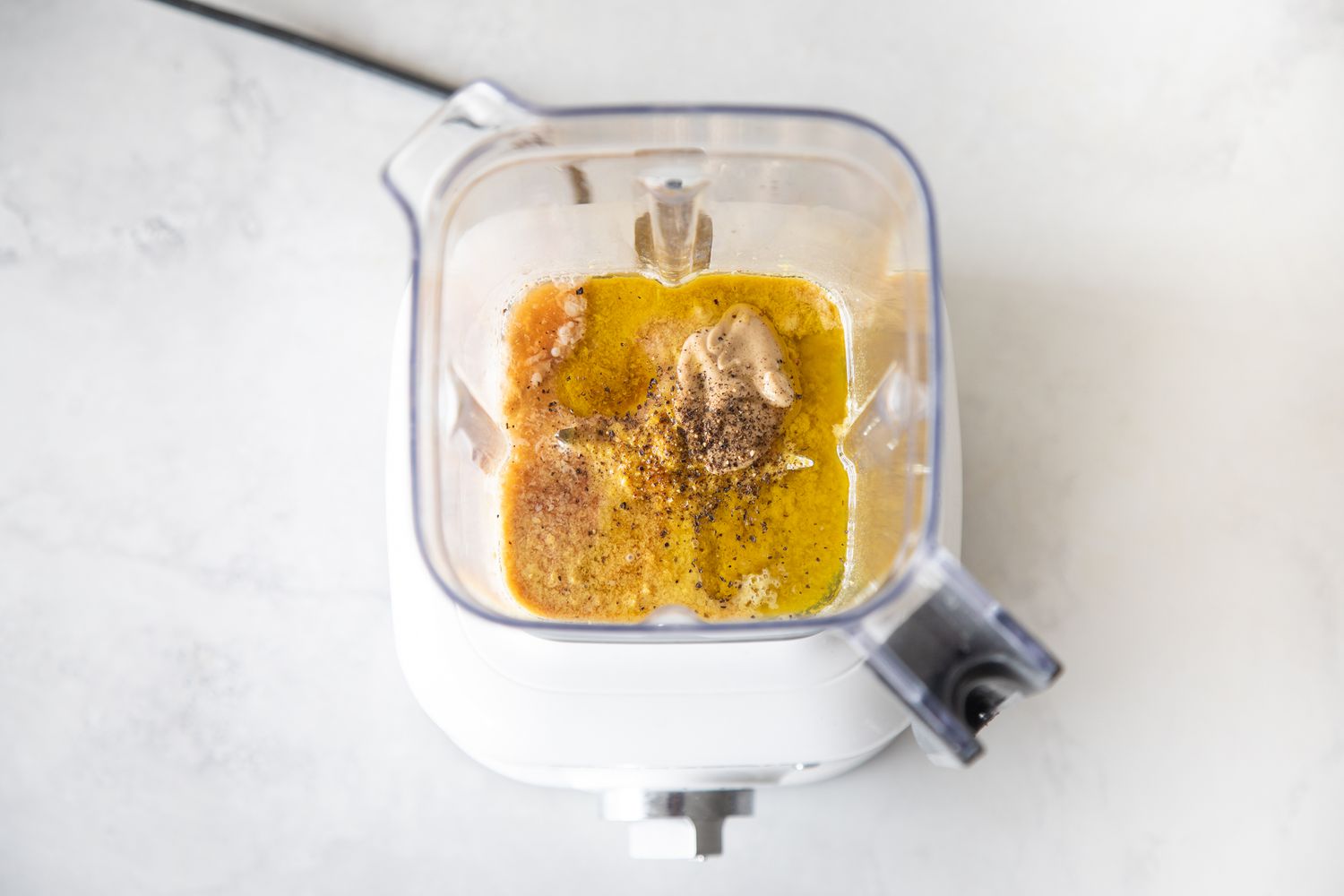 Blend tahini and ingredients for vegan caesar dressing