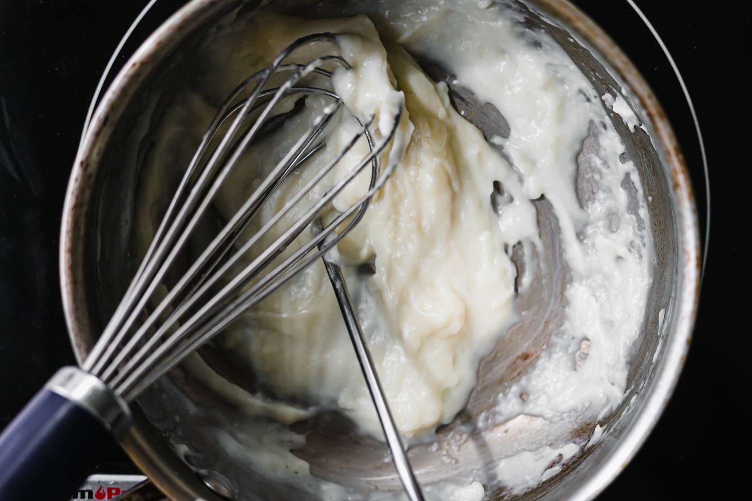 Whisking a tangzhong in a metal bowl to make pull apart rolls.