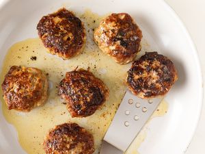 Plate of cooked German meatballs with a spatula