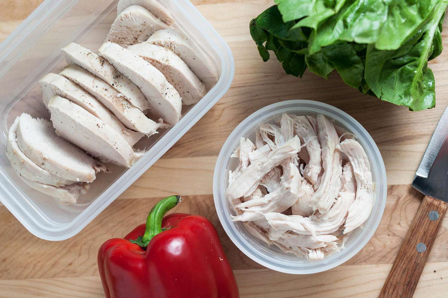 Sliced and shredded cooked chicken breast on a cutting board