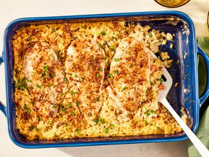 no-peek chicken in a casserole dish at a table setting with two glasses and a table napkin