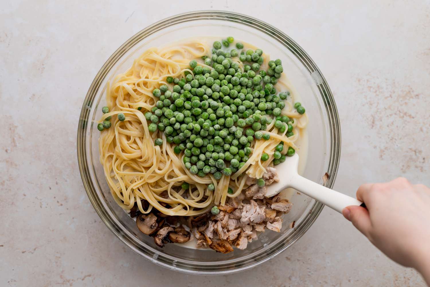 Pasta, turkey, and peas in a bowl to make a Turkey Tetrazzini Recipe.