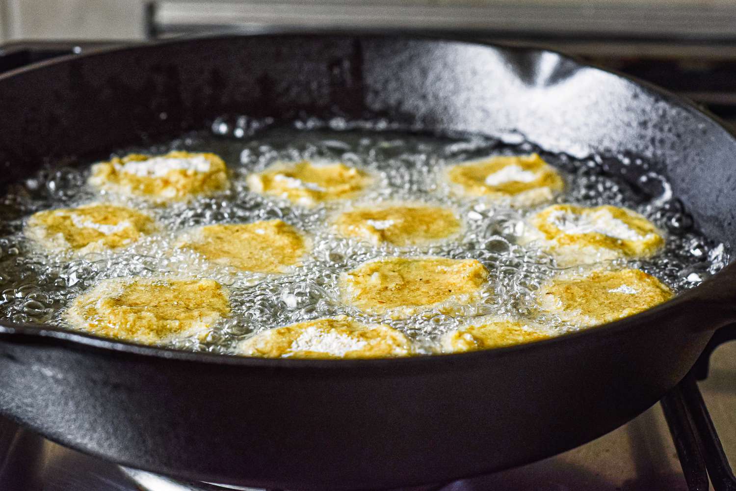 Frying green tomatoes in a cast iron skillet for fried green tomatoes.