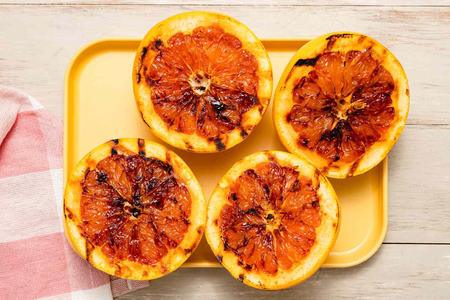 Grilled Grapefruit Paloma on a Platter Next to a Kitchen Towel on the Counter