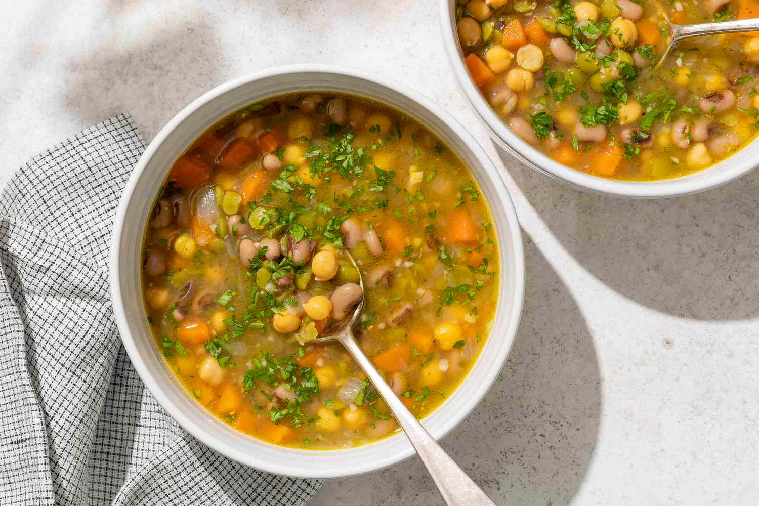 Bowl of threepea soup with a spoon on a table