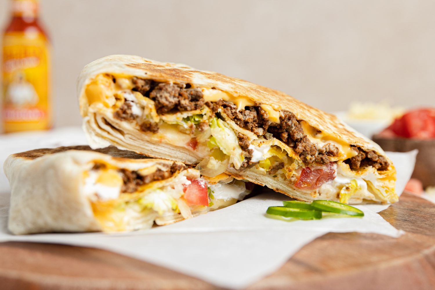 Copycat Crunchwrap Supreme Wrap on Parchment Paper Over a Wooden Board