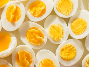 Hardboiled eggs sliced in half displaying yolks in varying consistencies arranged closely together