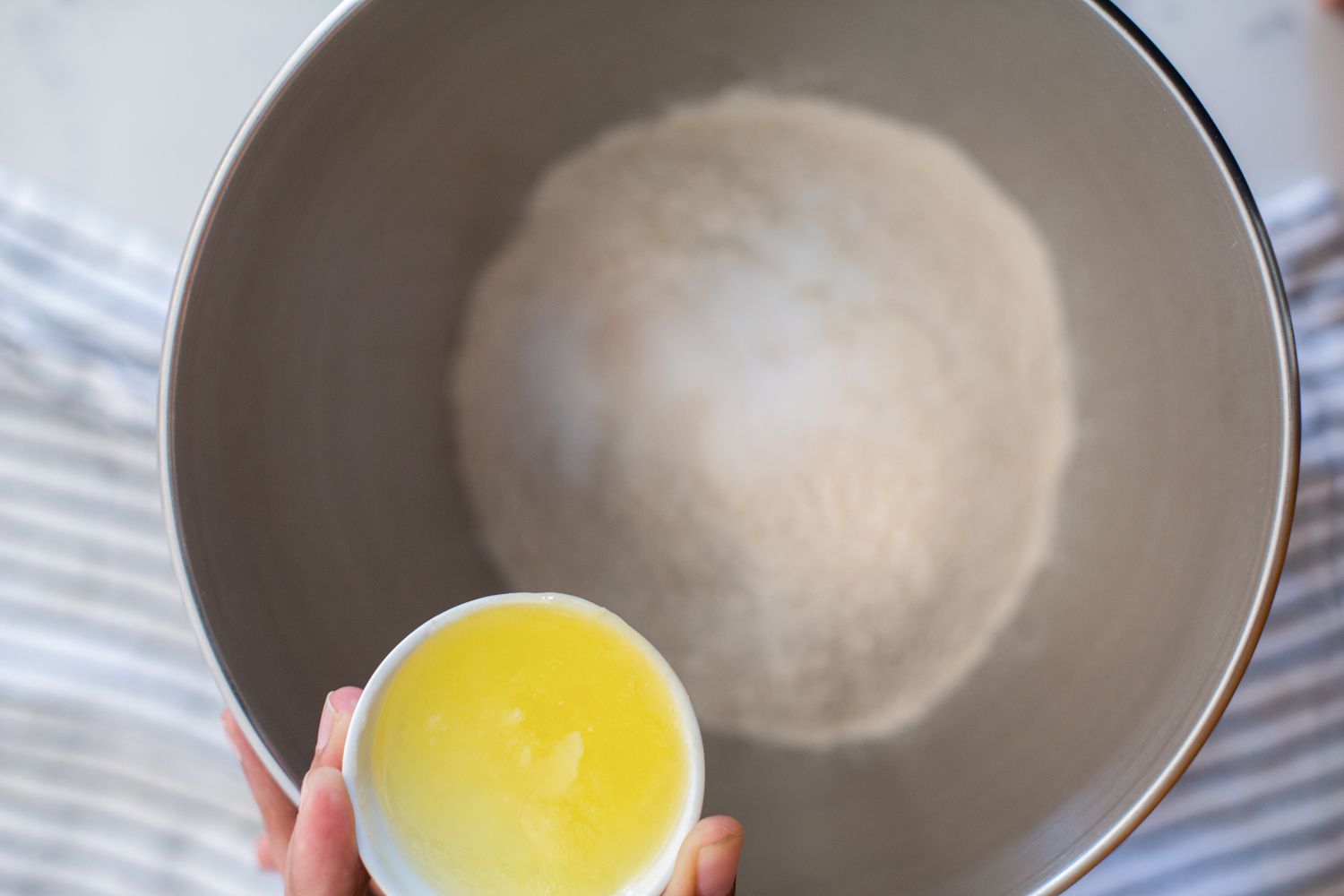 Adding ingredients to a bowl to make a roti recipe.