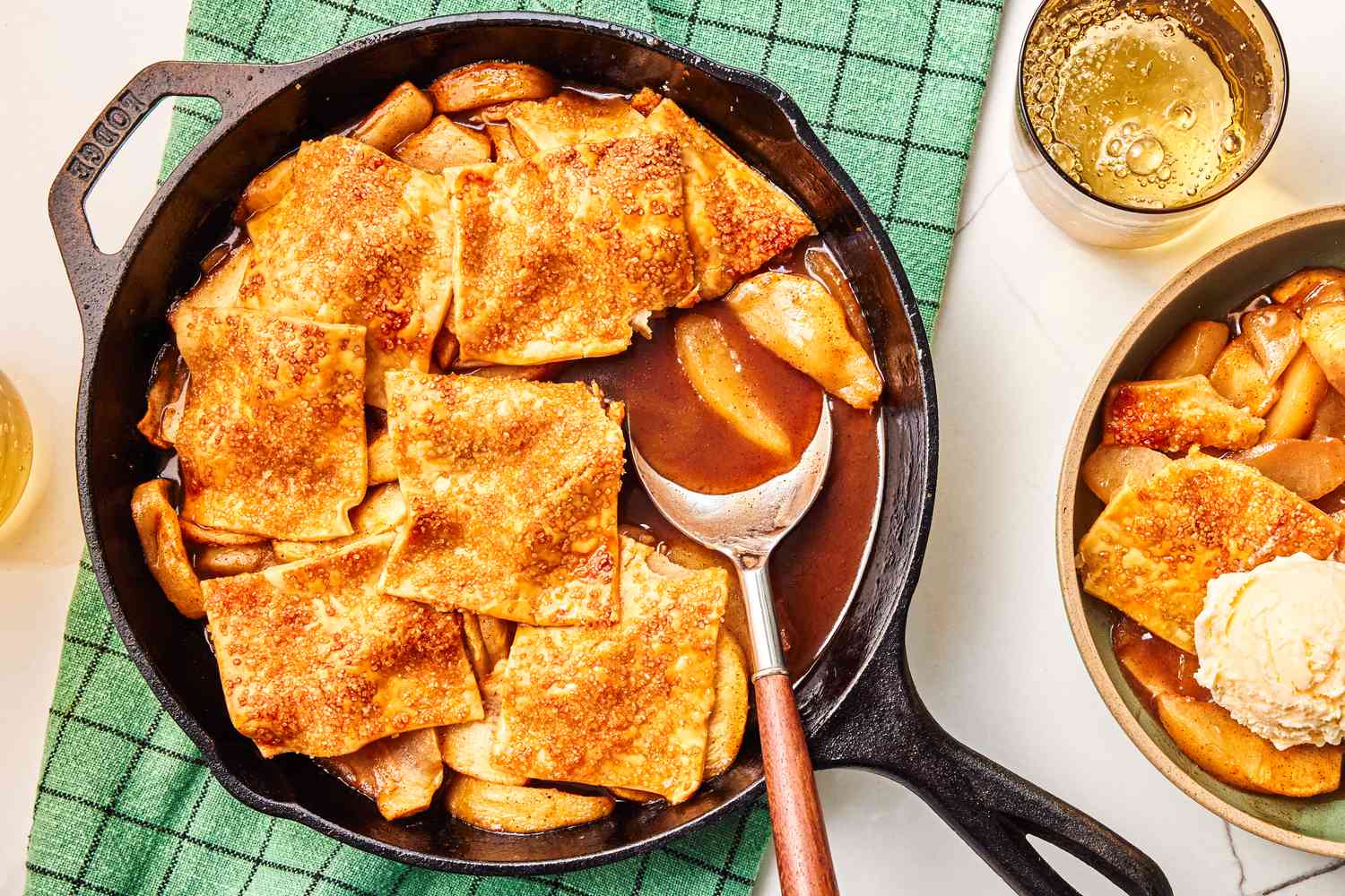 apple pandowdy in a cast iron skillet with a serving on a plate next to it