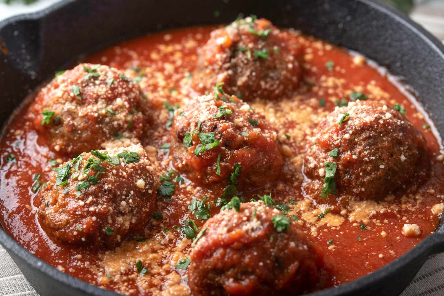 meatballs with tomato sauce in a cast iron skillet