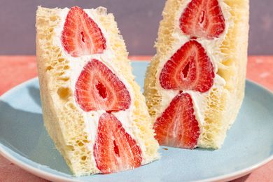 Two slices of strawberry and cream fruit sandwich on a plate