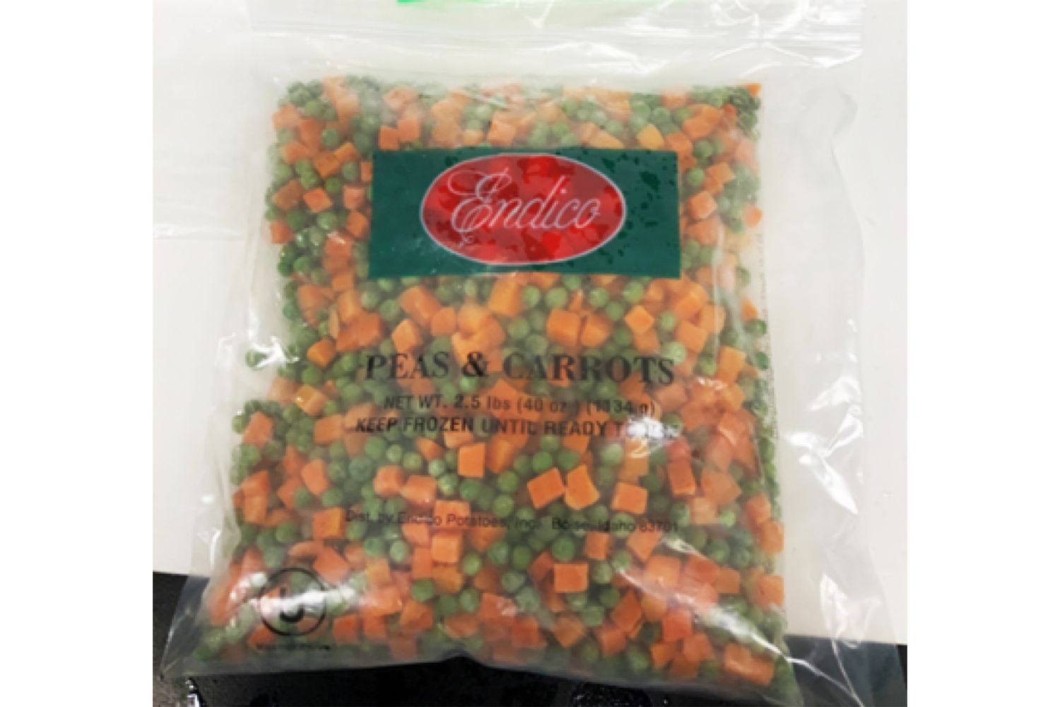 Packaged frozen peas and carrots labeled as Endico brand in a clear plastic bag
