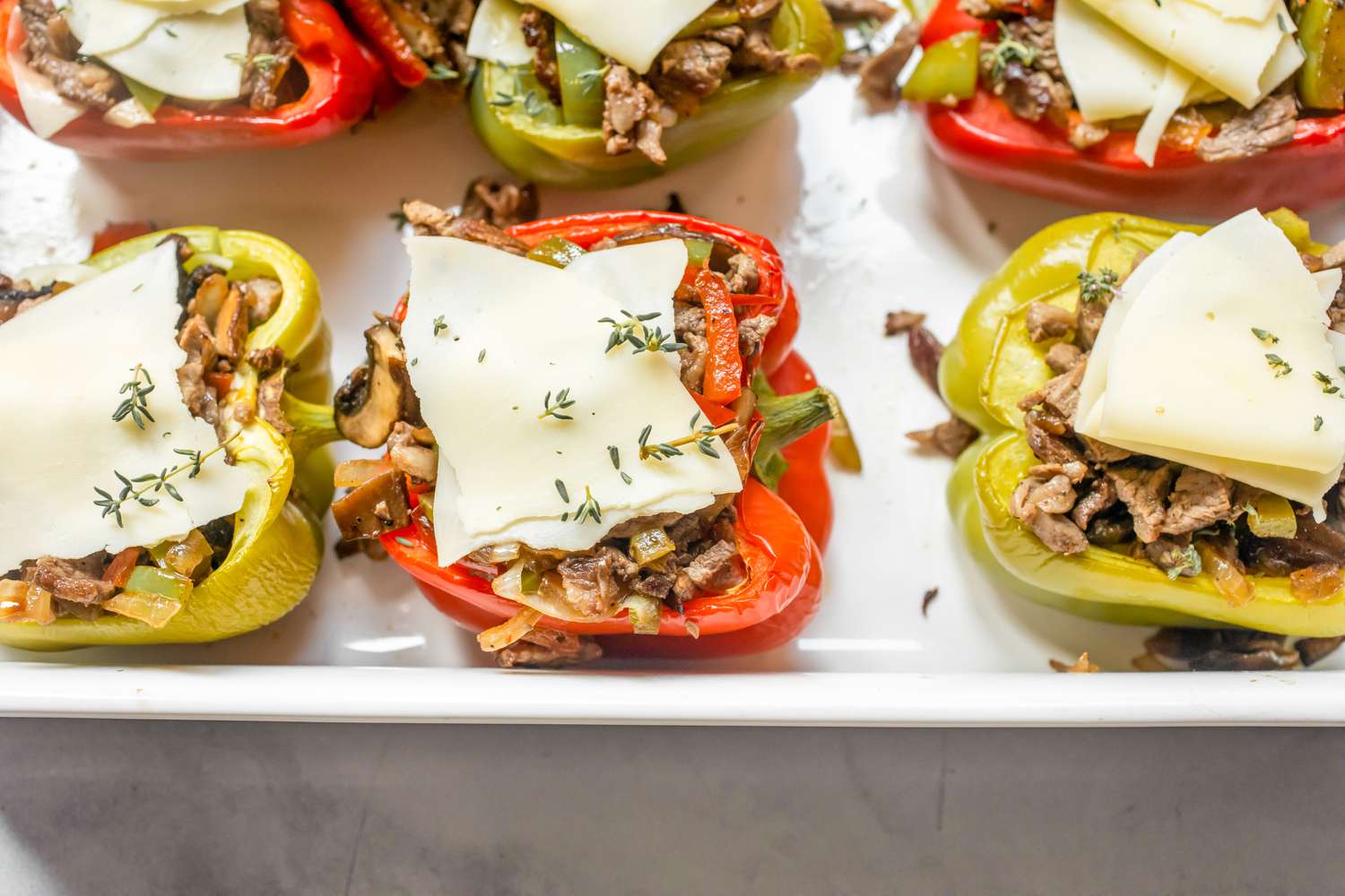 Bell Peppers Filled and Topped with Cheese and Herbs for Philly Cheesesteak Stuffed Peppers Recipe