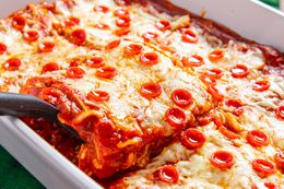 Spatula Slightly Lifting a Slice of Pepperoni Pizza Lasagna From a Casserole Dish With the Rest of the Lasagna