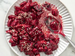 Overhead shot of a plate with chopped pieces of beets in a creamy sauce, topped with sesame seeds