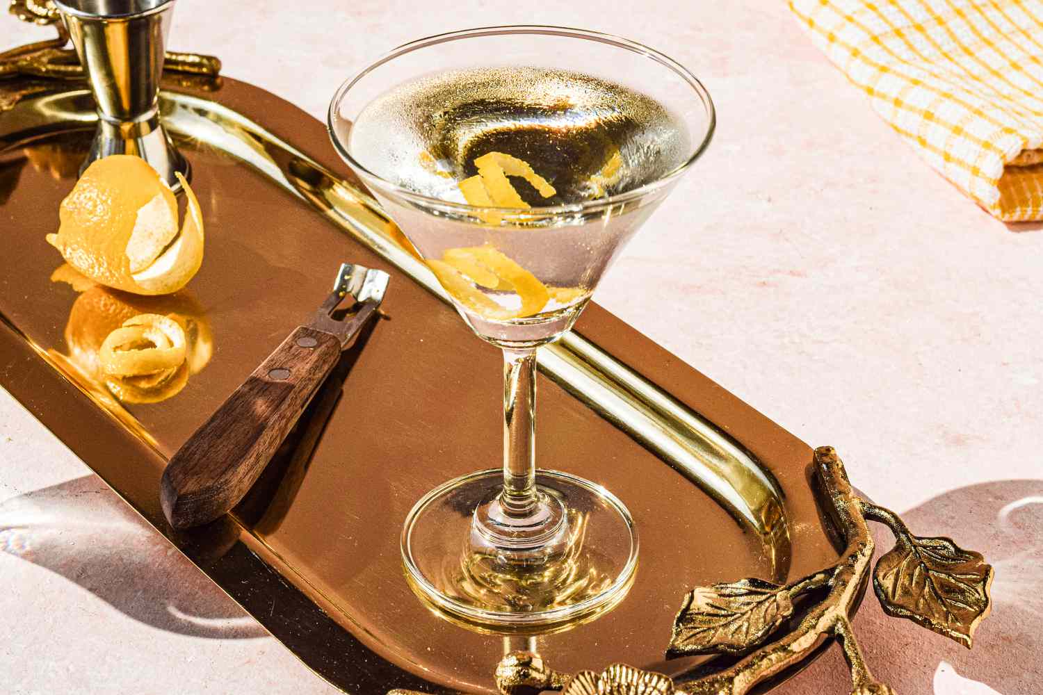 Classic Vodka Martini on a tray with lemon zest in background