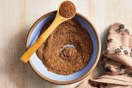 Bowl of Fajita Seasoning With Some in a Spoon Resting on the Bowl, and on the Counter, a Kitchen Towel