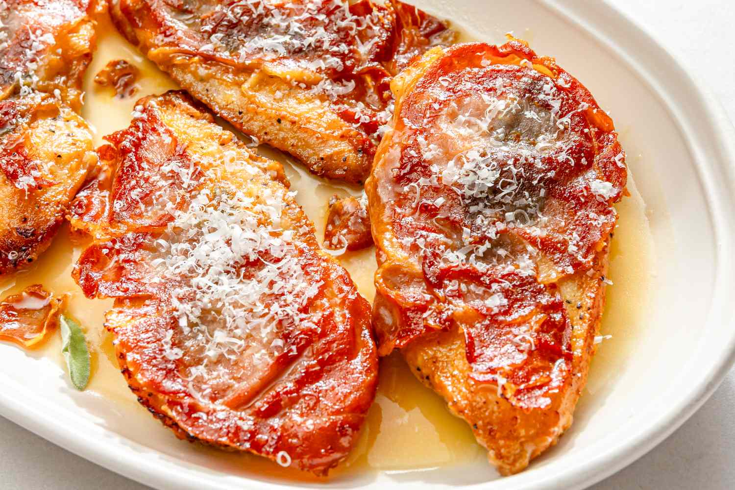 Chicken saltimbocca served on a plate with prosciutto and sauce