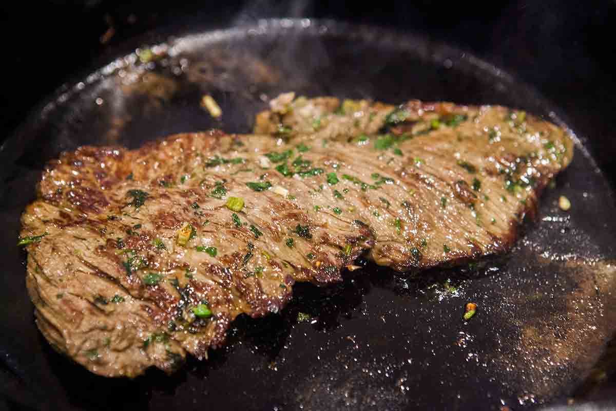 brown steak in cast iron pan for steak fajitas