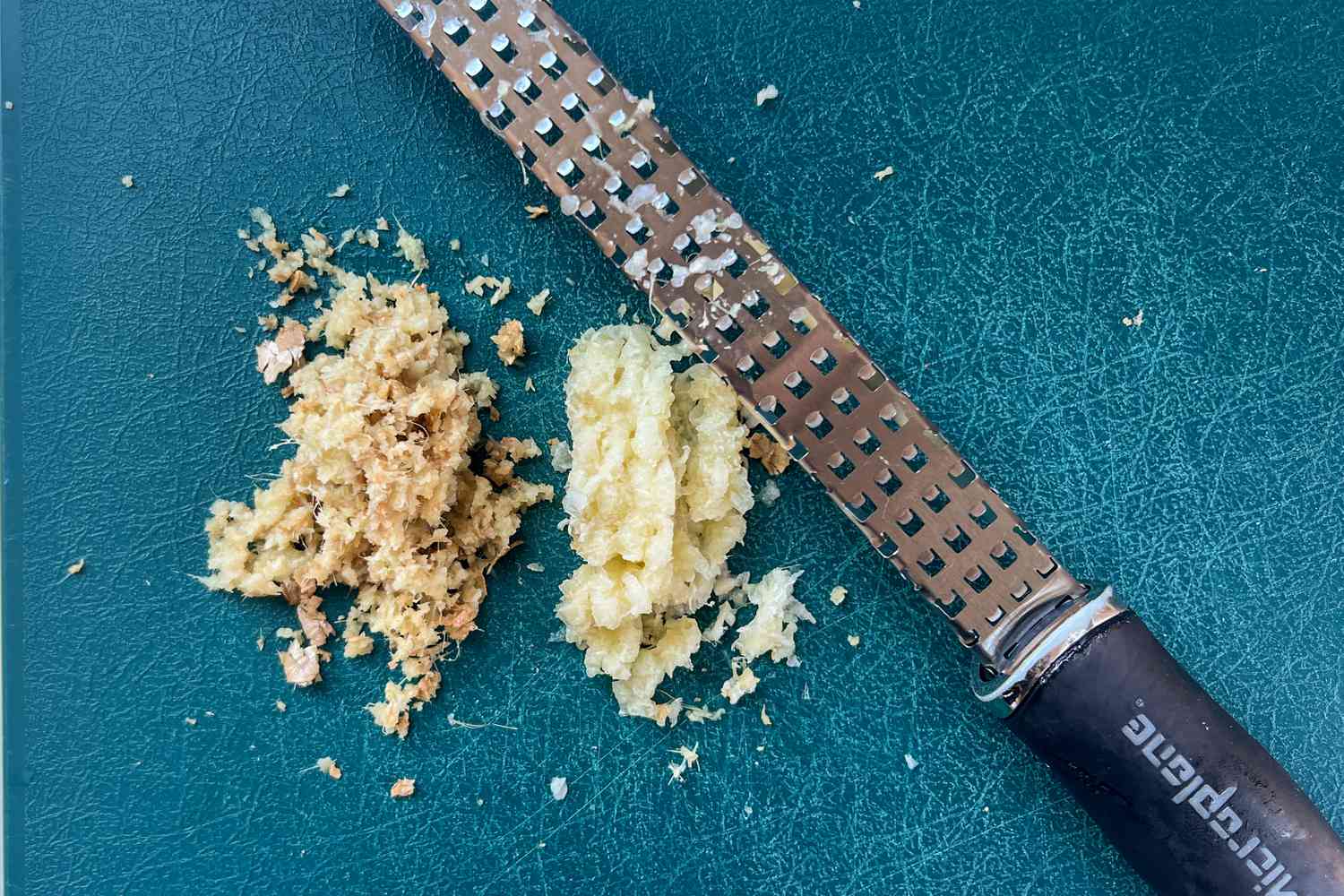 Ground ginger and garlic next to a Microplane