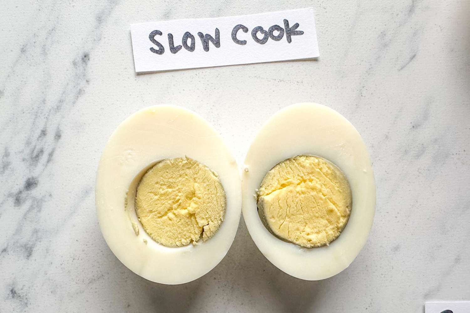 Two halves of a hardboiled egg showing the yolk labeled Slow Cook above the egg