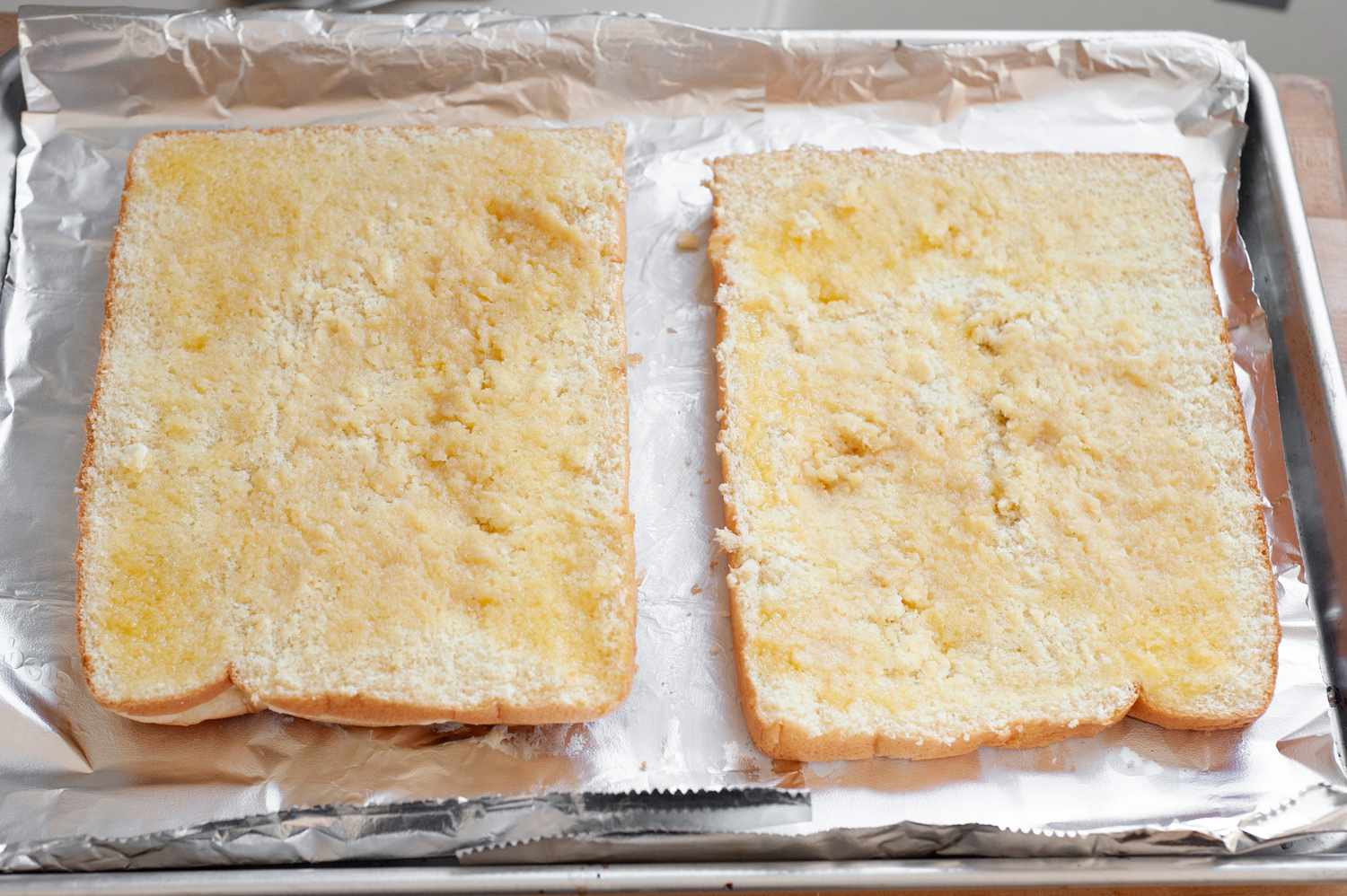 Hawaiian Roll Sliders Buttered on a Baking Sheet 