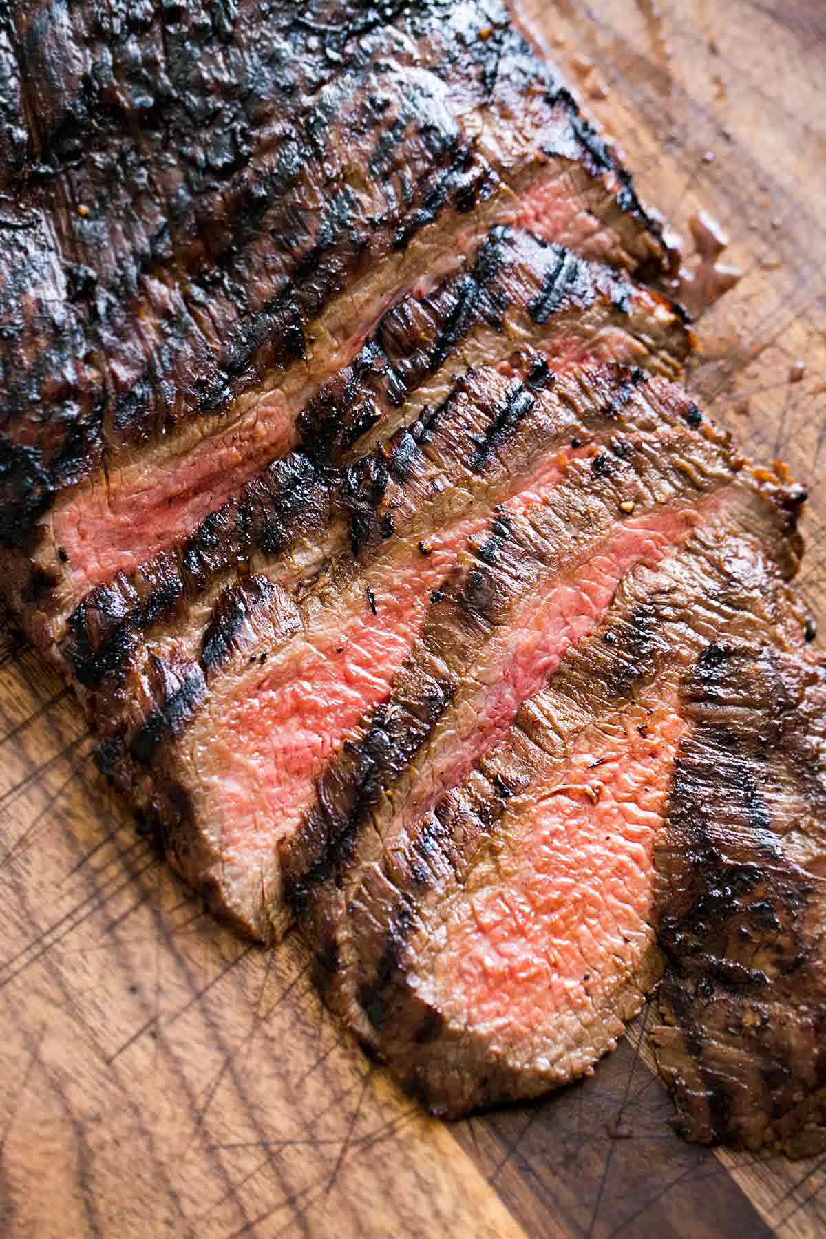Grilled Marinated Flank Steak sliced on a cutting board