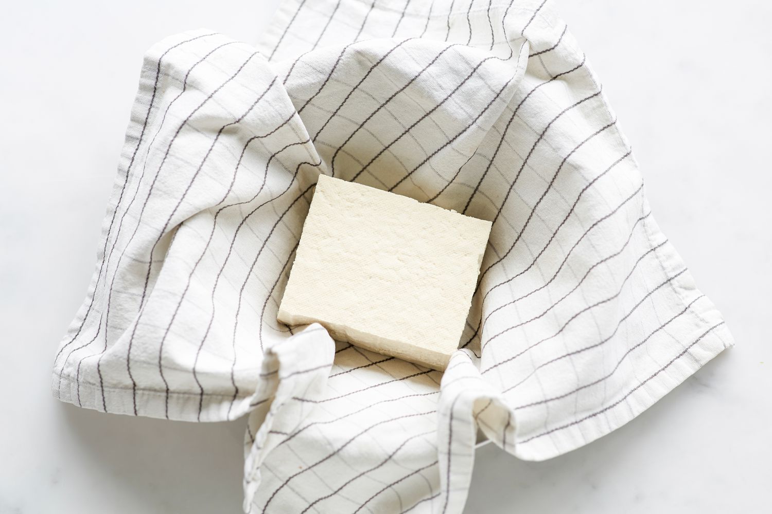 Draining tofu for Korean pork and chives dumplings.