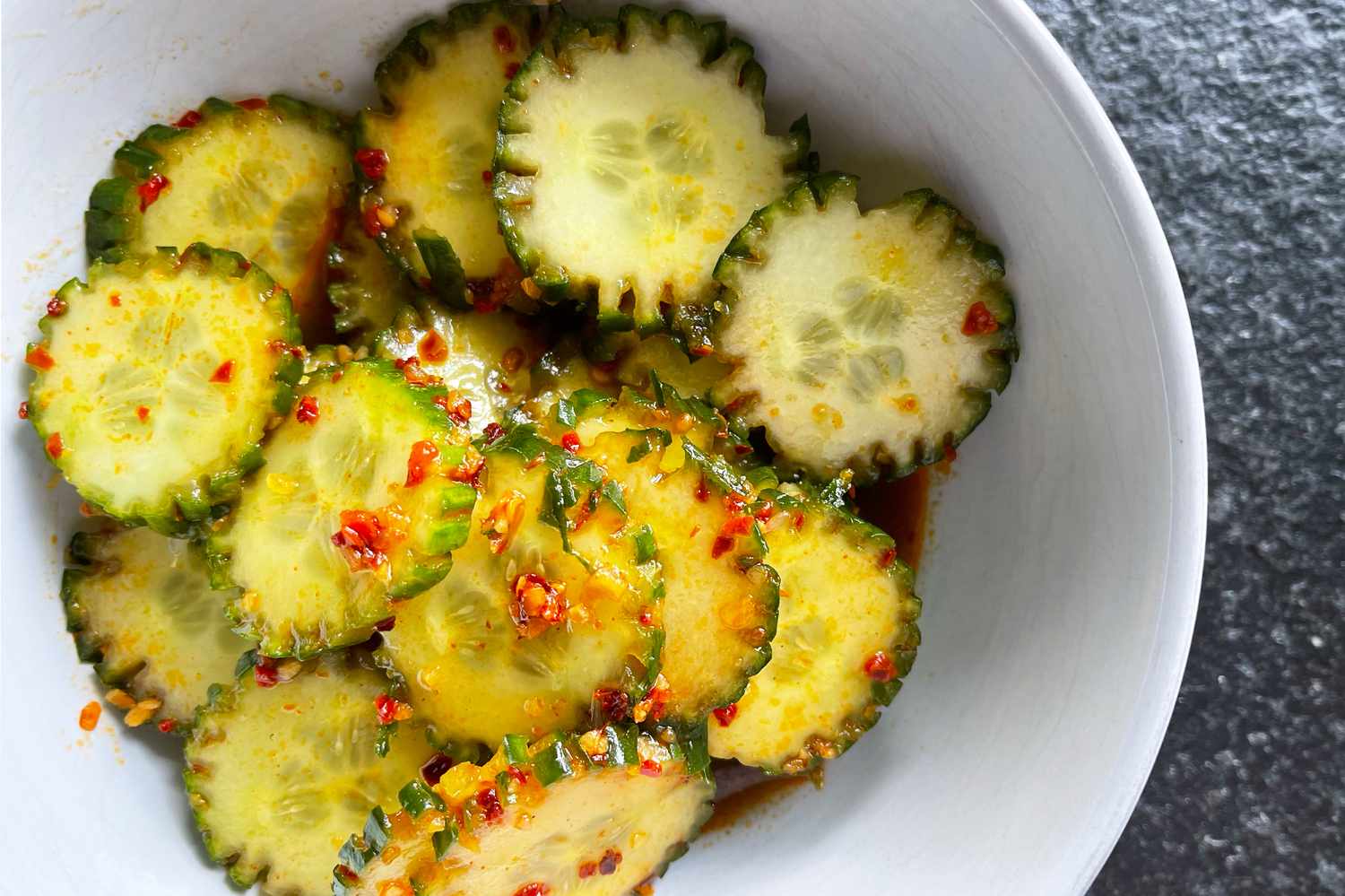 Cucumber salad in a bowl, garnished with seasonings