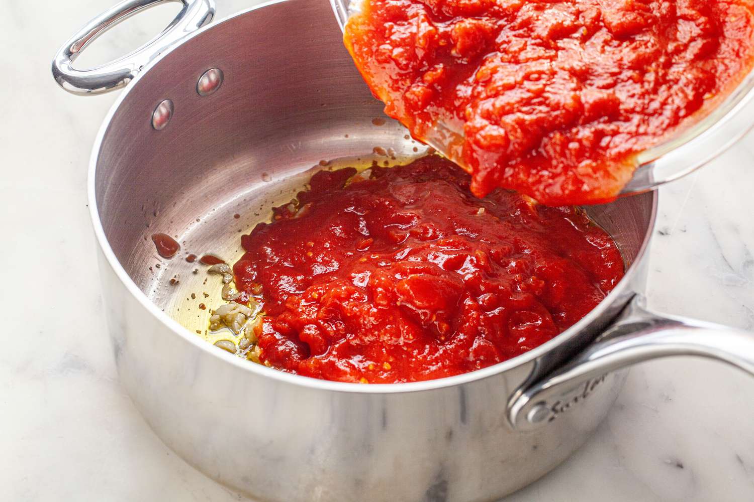 Crushed Tomatoes Added to Pot of Garlic for Marinara Recipe
