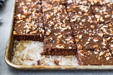 Texas chocolate sheet cake in a pan with a few pieces missing.