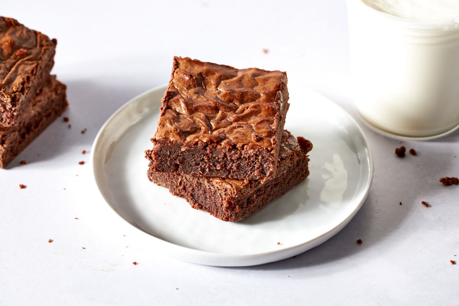 Side view of two brownies stacked on top of each other on a plate