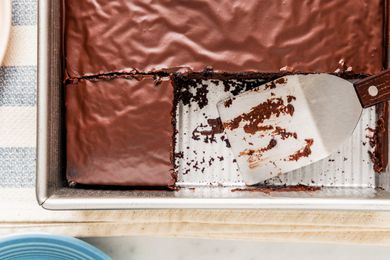 Chocolate depression cake in a baking pan with a few pieces already cut out