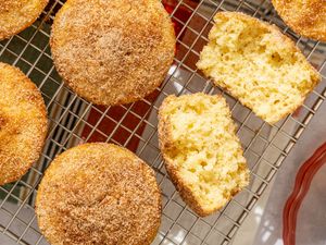 Old-Fashioned Donut Muffins on a cooling rack, one broken open