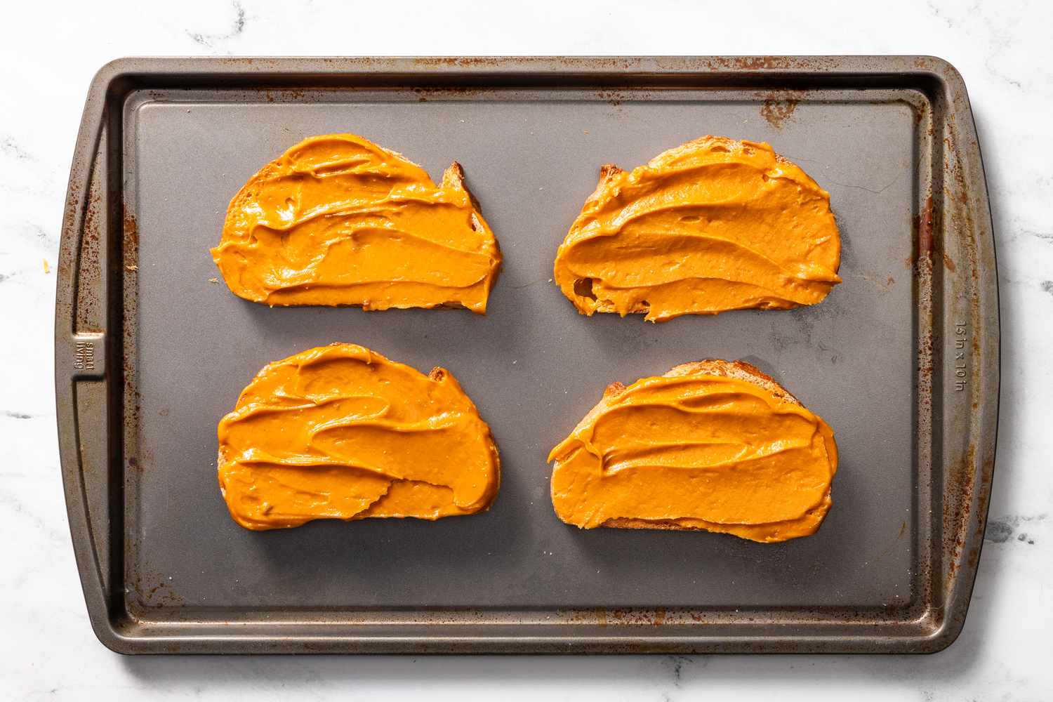 Cheese spread onto the slices of toast for welsh rarebit recipe