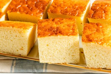 Several slices of spongy condensed milk cake on a beige background