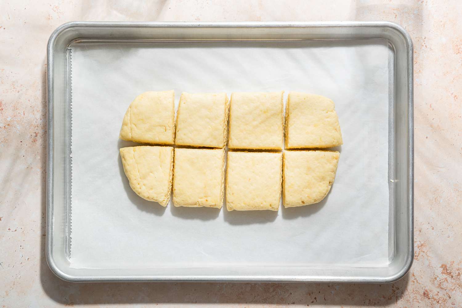 Overhead view of the dough squares placed on a baking sheet with parchment paper for Mayonnaise Biscuits recipe