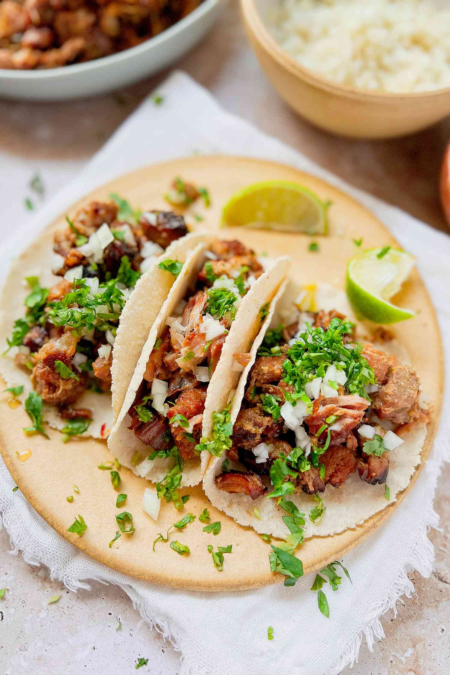Carnitas Tacos with Chopped Cilantro, Diced Onions, and Lime Wedges