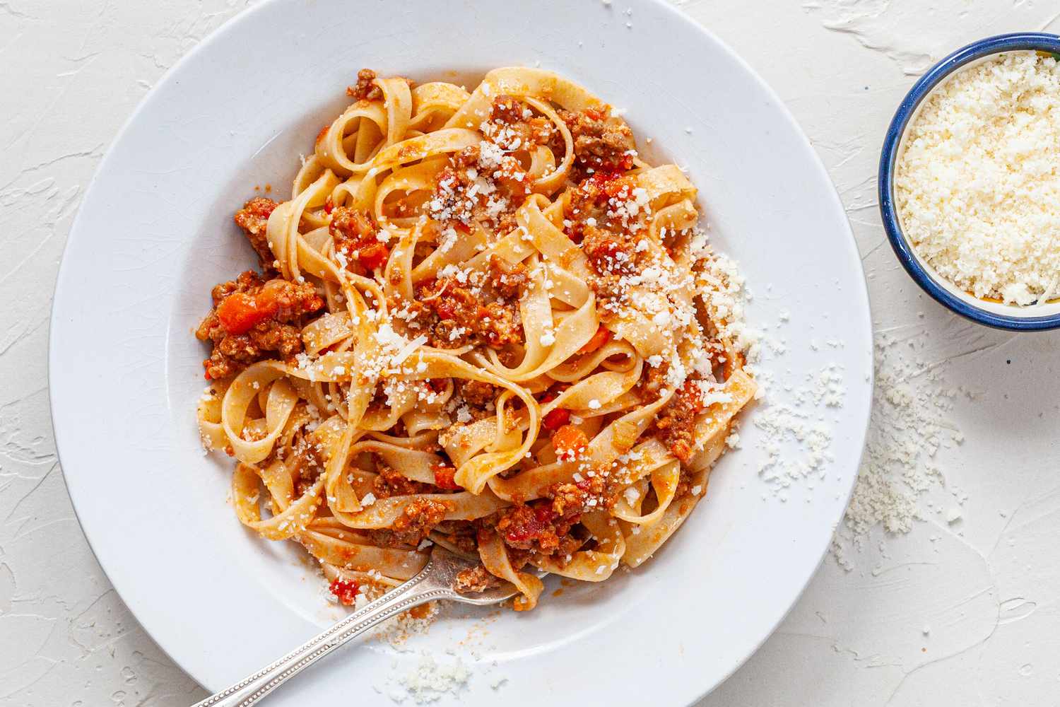 Pasta with bolognese sauce on a white plate.