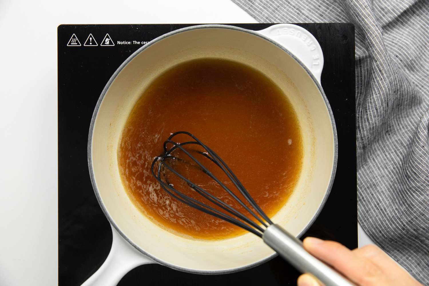 Beef Stock, Soy Sauce, Shaoxing Wine, Oyster Sauce, and White Pepper Powder Whisked Together in a Pot on a Portable Stove for Egg Foo Young Sauce