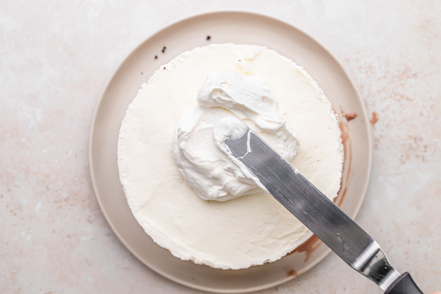 Ice Cream Cake Iced with Whipped Cream on Plate Using Offset Spatula